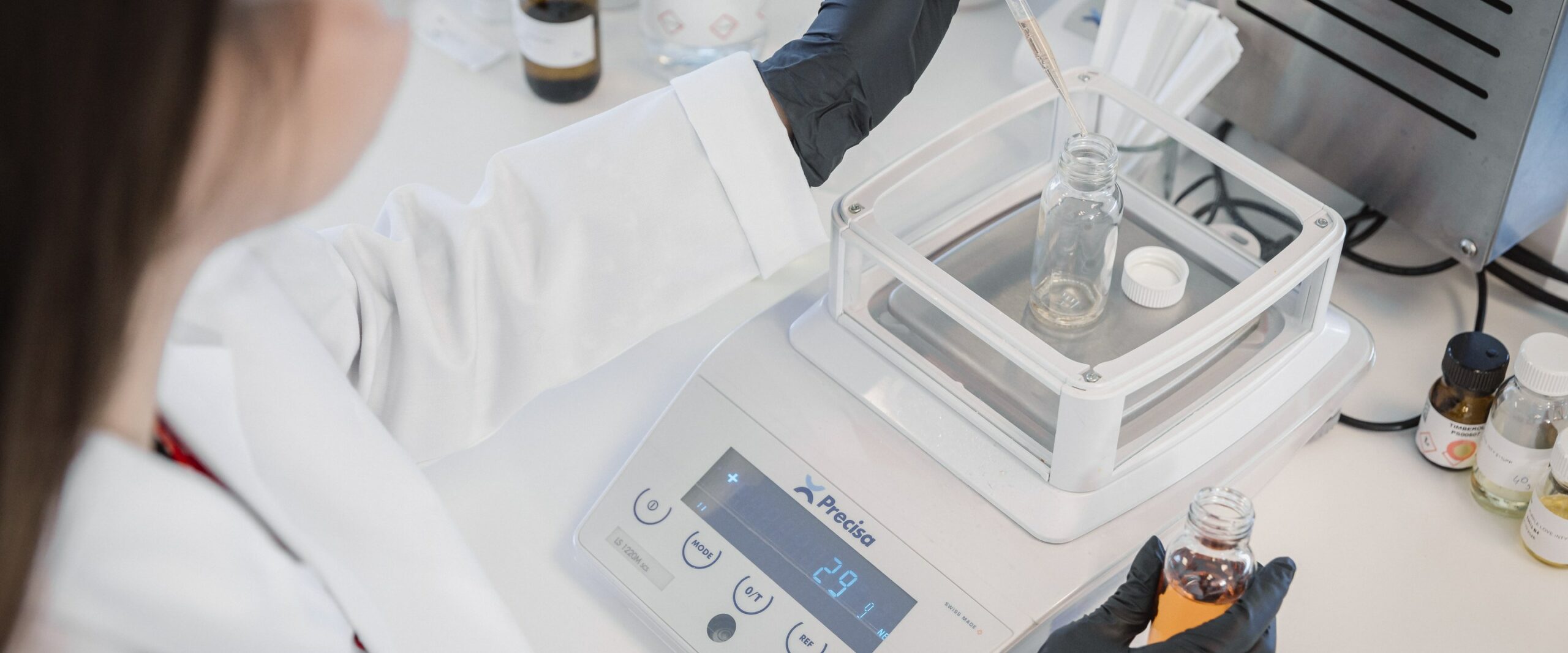 Pesée de précision d'une formule de parfum au laboratoire PERFUM de Grasse